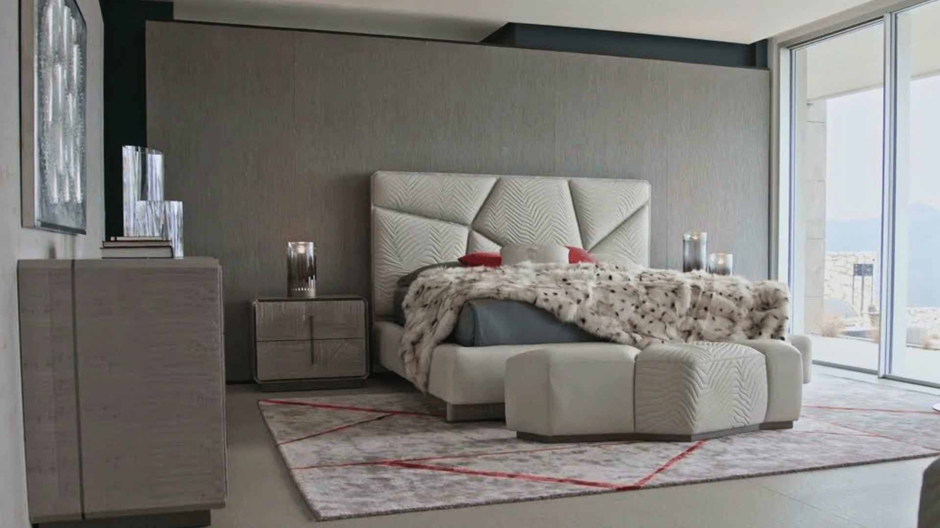 Modern bedroom with a large bed, geometric headboard, fur throw, and glass doors. Neutral tones create a serene atmosphere.