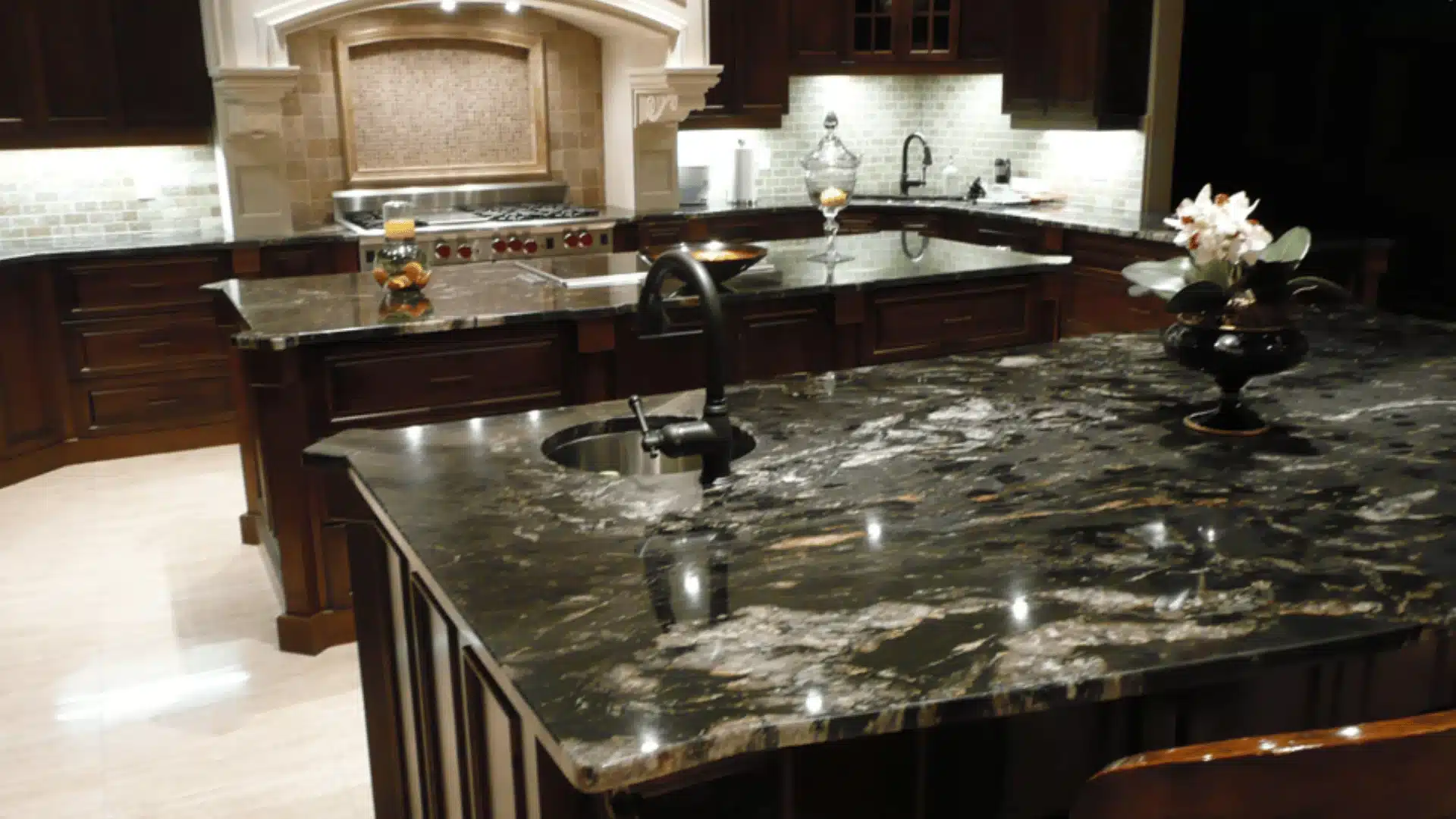 A high-end modern kitchen interior featuring a luxurious titanium countertop with dramatic white veining patterns.