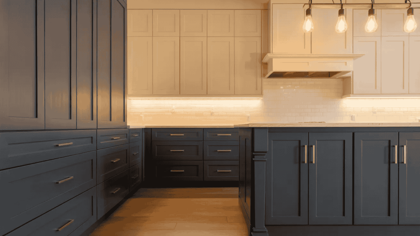 a spacious, modern kitchen featuring charcoal cabinets, cream upper cabinets, and white subway tile backsplash