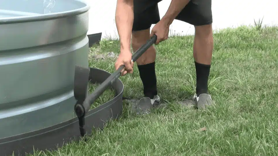 cutting grass edge around stock tank area to prepare landscaping border