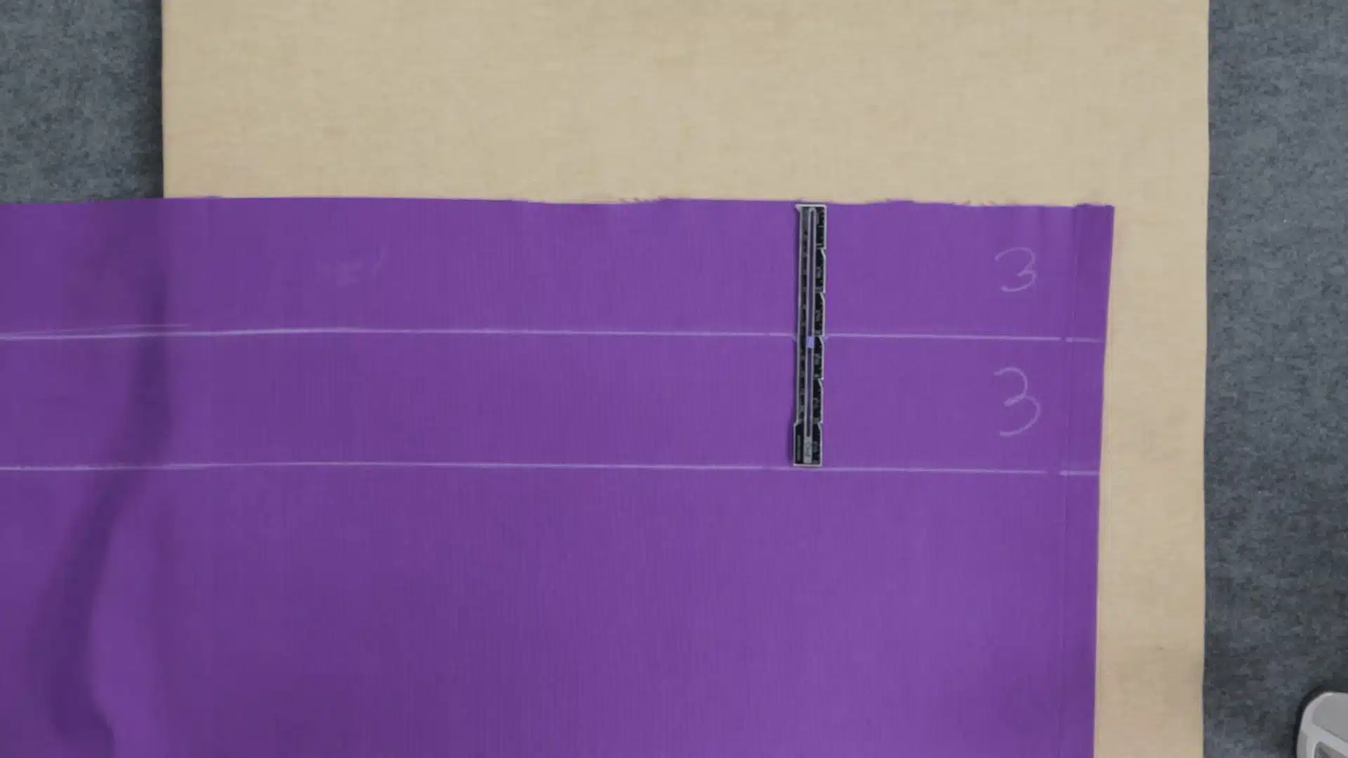 picture showing the measurement of three for the purple curtain on the cardboard