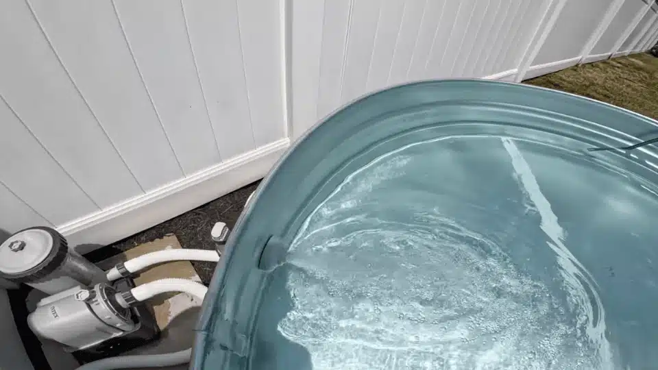 water flowing from the inlet nozzle into a filled stock tank pool while the filter pump runs