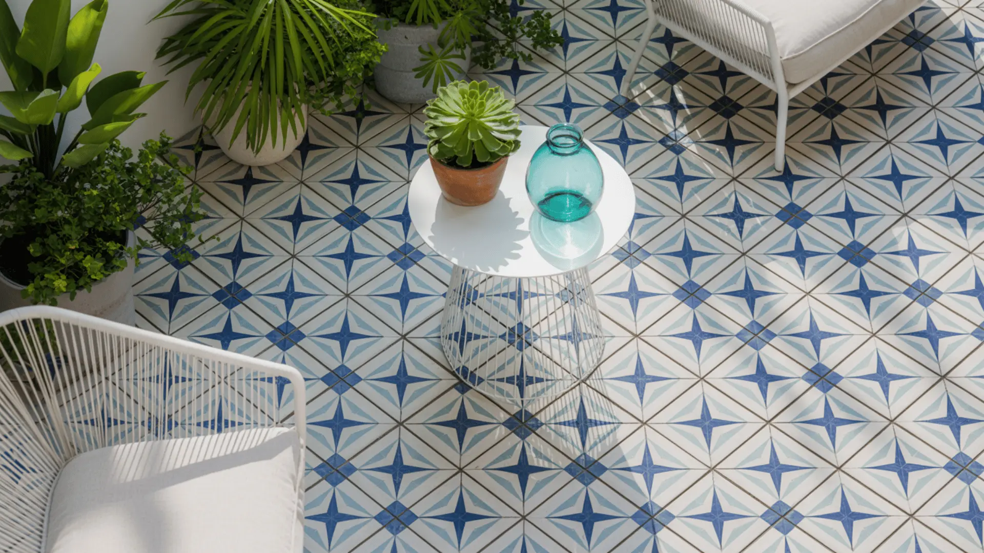 a high-angle view of a modern outdoor patio space with decorative blue and white geometric tile flooring