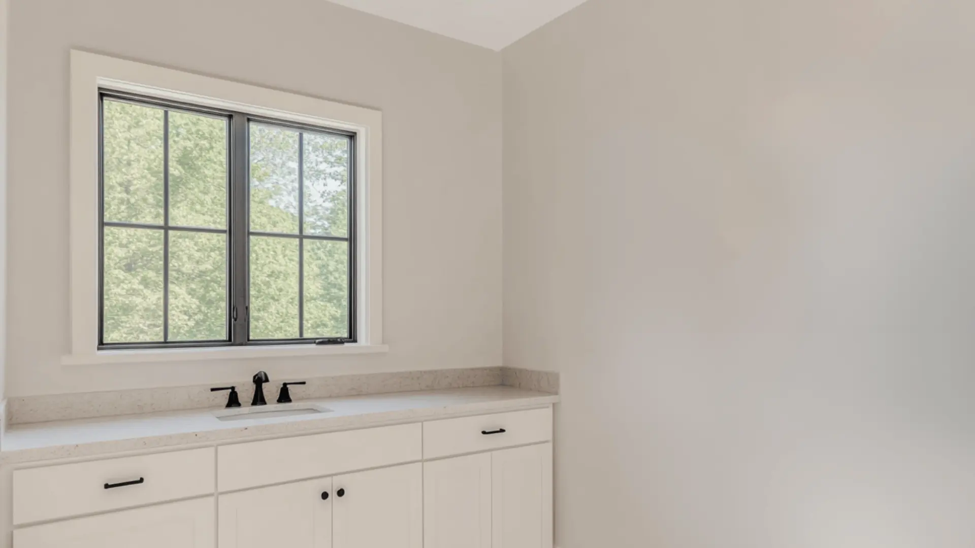 clean bathroom with alpaca paint on walls, white shaker vanity, black fixtures, and a black-framed window