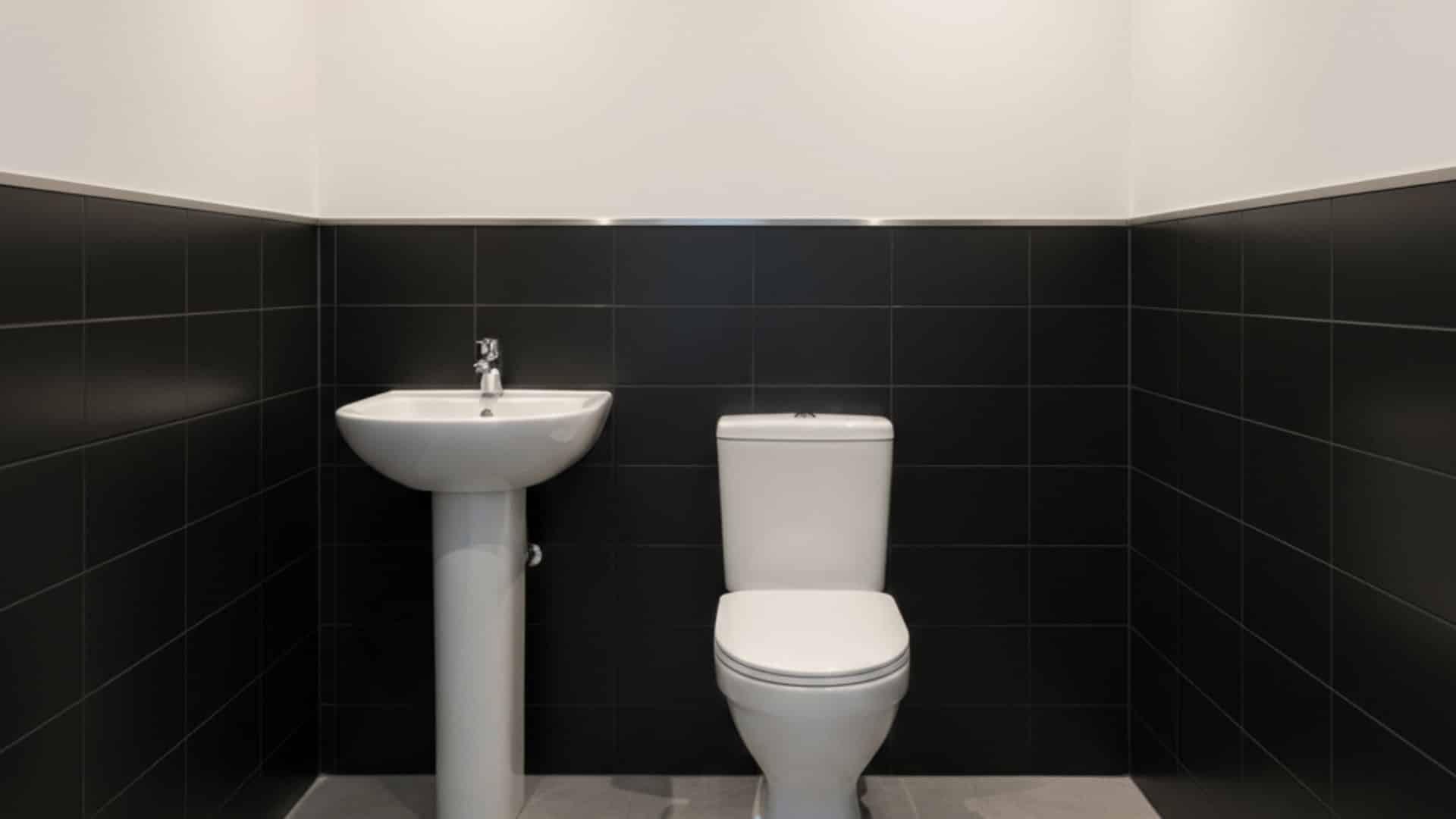 small white bathroom with black floating vanity, vessel sink, matte black faucet and black framed mirror