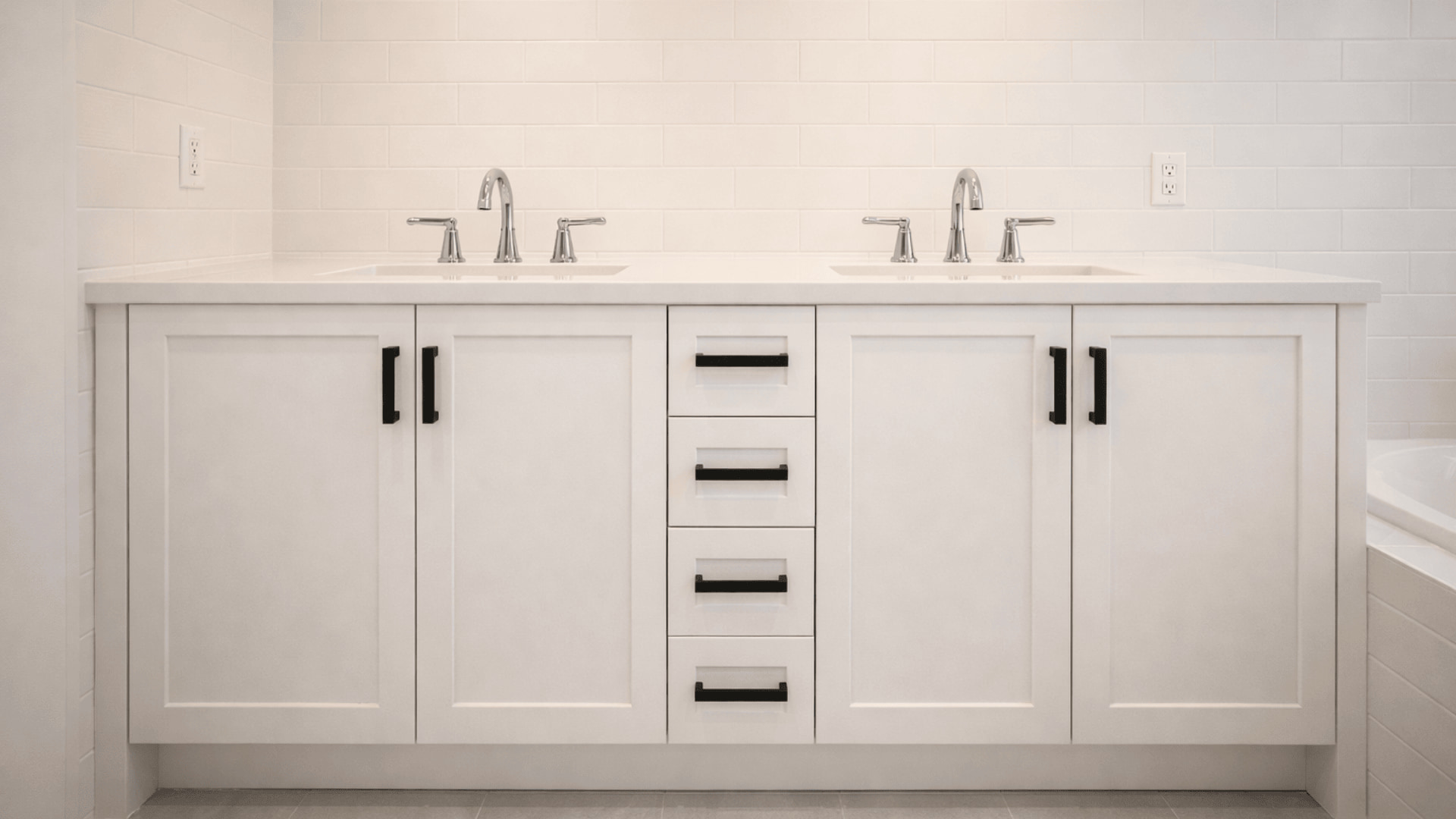 white shaker double vanity with matte black bar pulls, chrome faucets and white subway tile walls