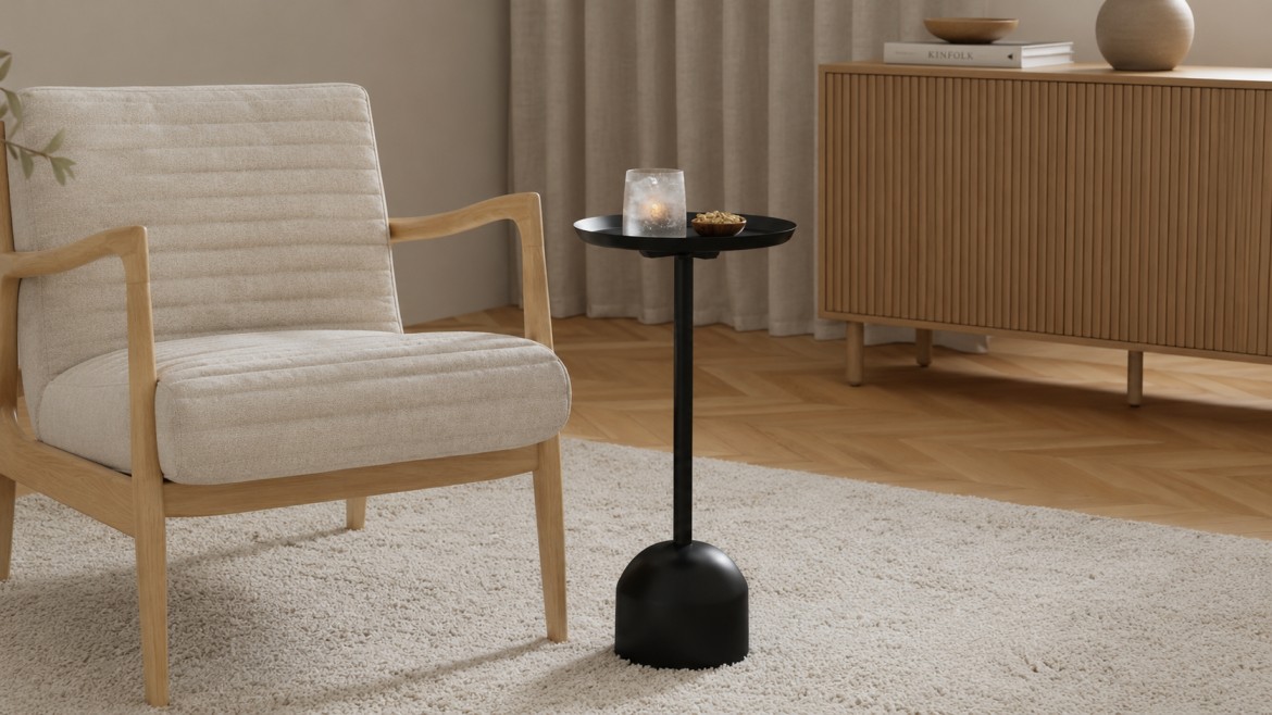 A cozy living room with a beige armchair, a drink table holding a glass and small bowl,