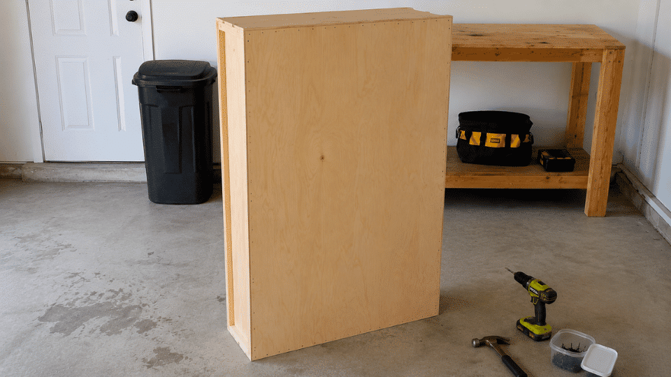 attaching a plywood back panel to the bookshelf frame