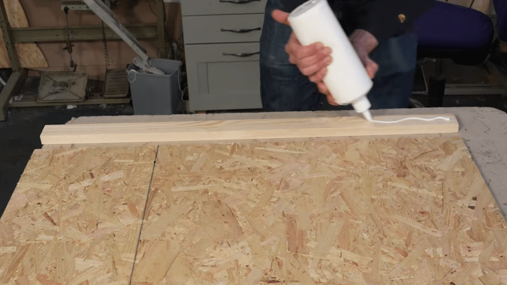 _attaching wooden batten frame to headboard board using glue and screws on workshop table
