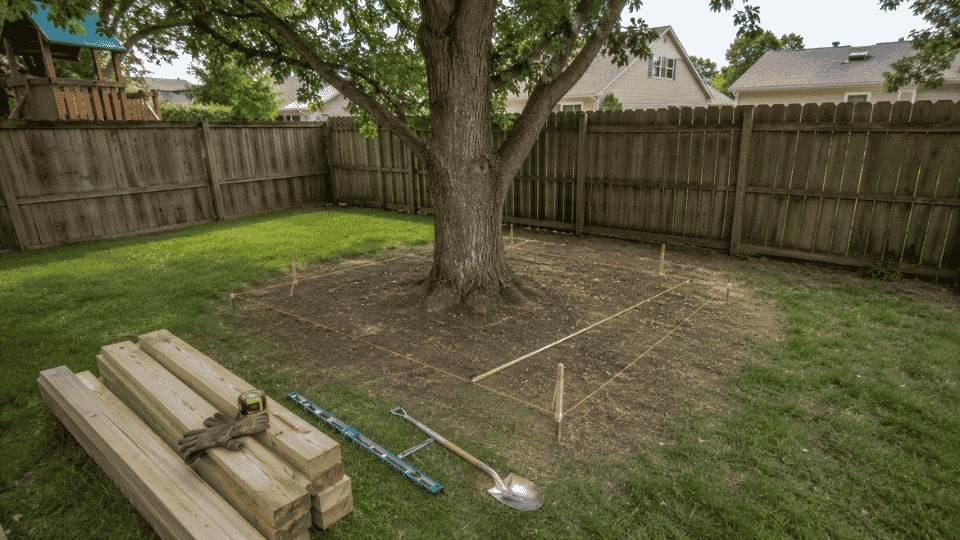 backyard tree marked for an 8x8 kids treehouse layout with stakes and string