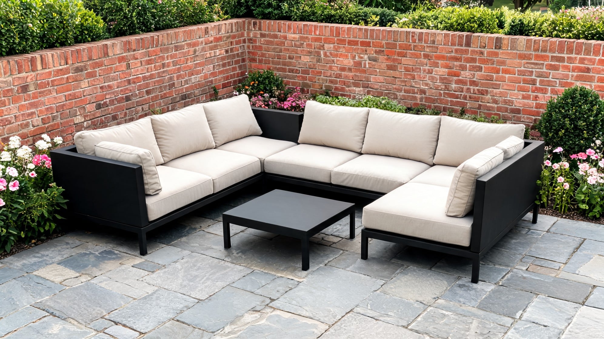 Black outdoor corner sectional with beige cushions in a garden corner