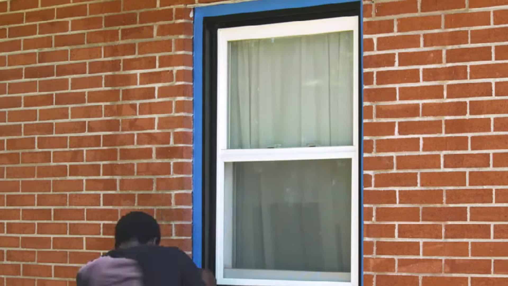 covering windows and plants with plastic sheets before painting brick house
