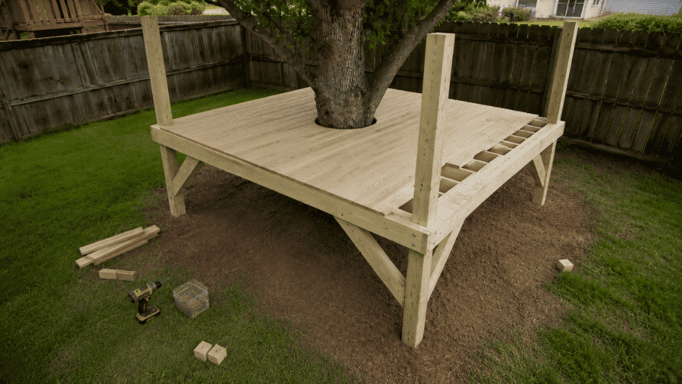 deck boards installed around the tree opening on a simple treehouse floor