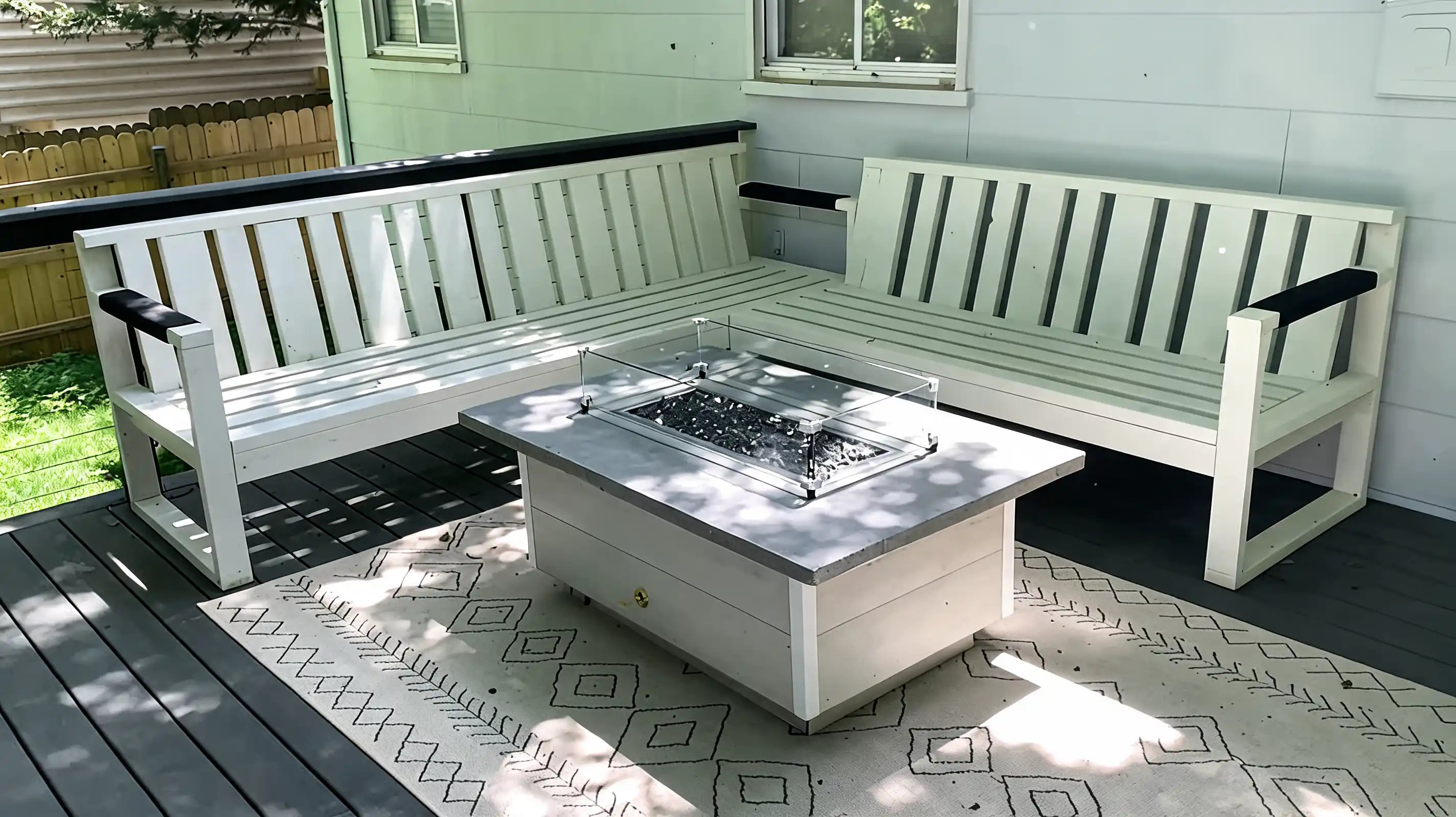 finished white outdoor sectional on a deck with fire pit table and patterned rug