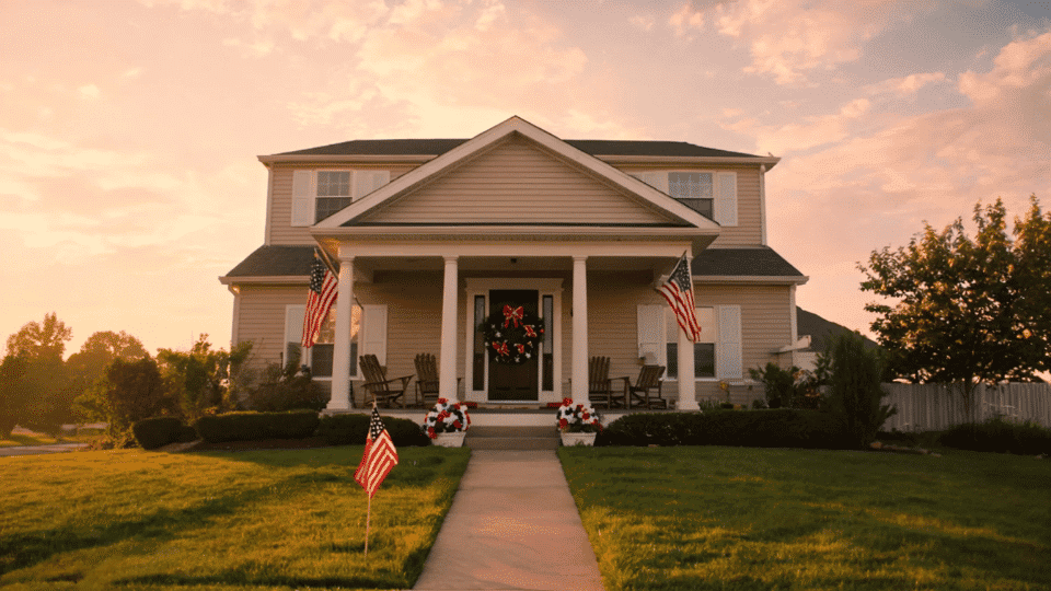 front porch with patriotic decor wreath and flags in soft golden hour light