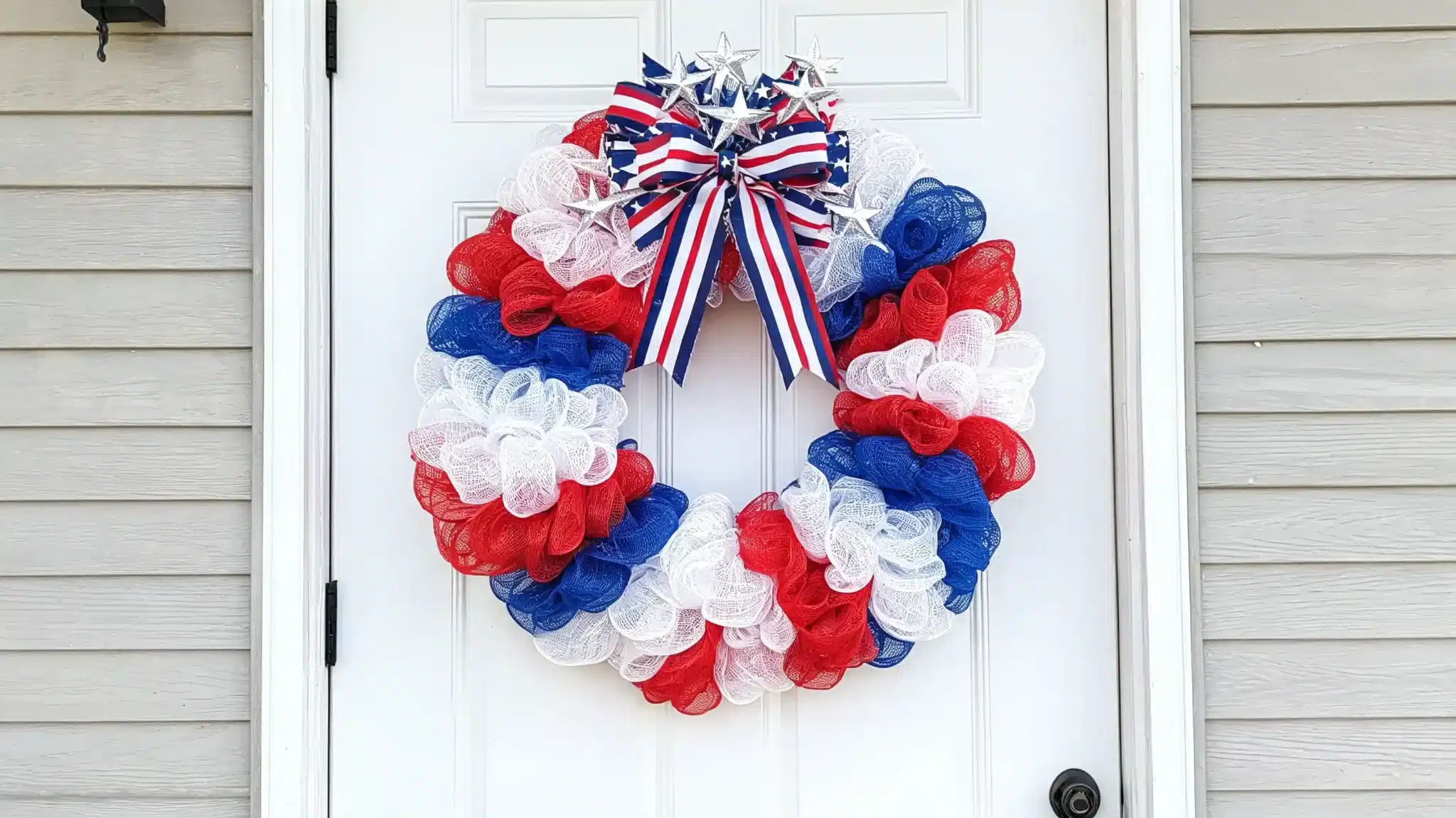 full deco mesh wreath in red white and blue with bow and star decorations