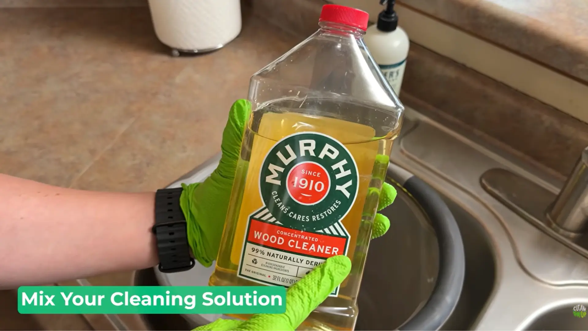 hand holding Murphy Oil wood cleaner while mixing a gentle solution for cleaning wood cabinets