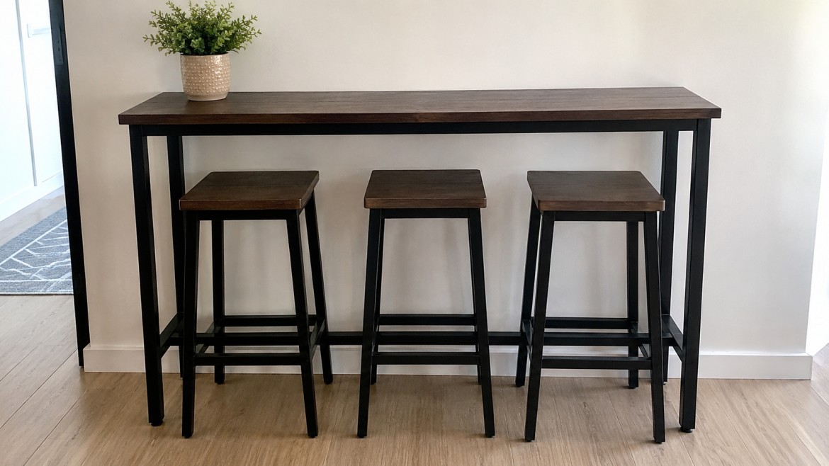 Modern wooden high top table with black metal legs, accompanied by three matching stools