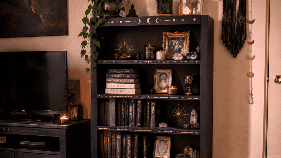 mystic painted bookshelf with candles crystals and astrology books