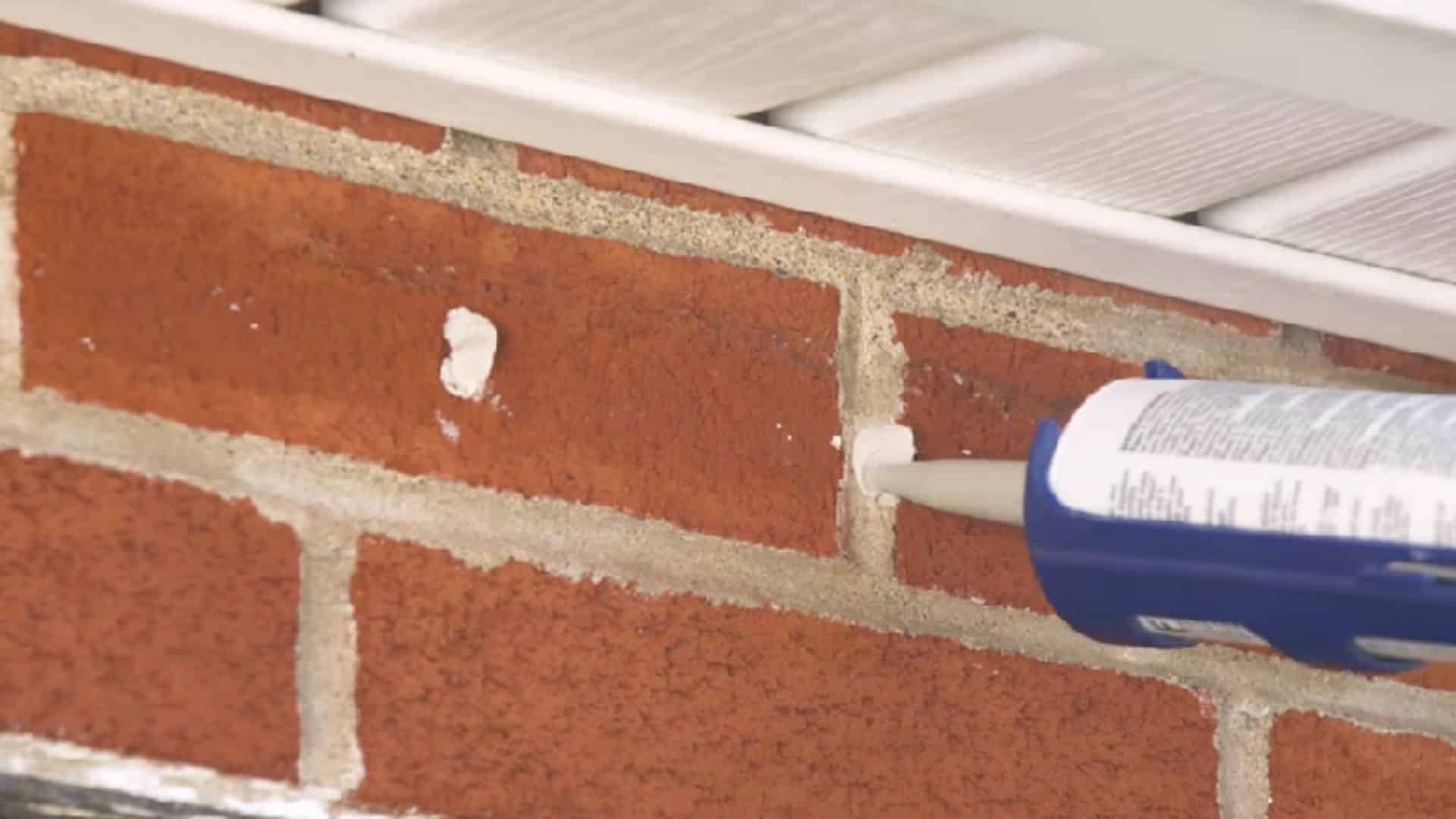 repairing cracks and mortar on brick wall before painting brick house