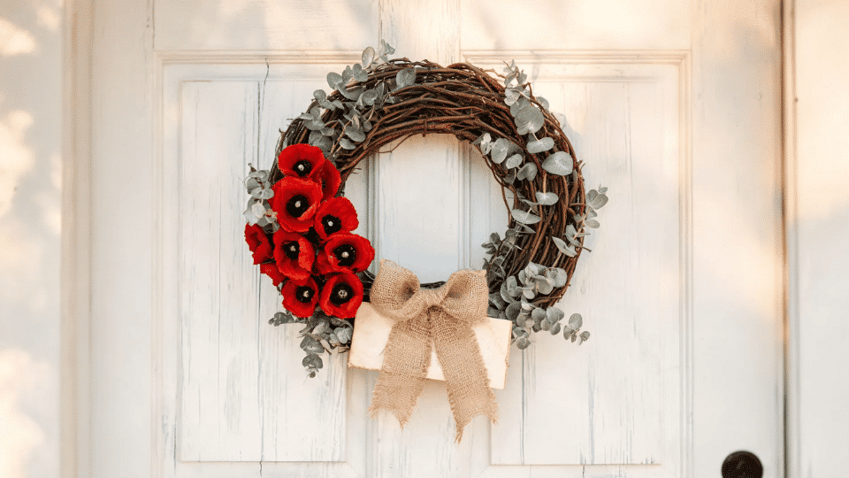 rustic grapevine wreath with red poppies eucalyptus and burlap bow on white front door