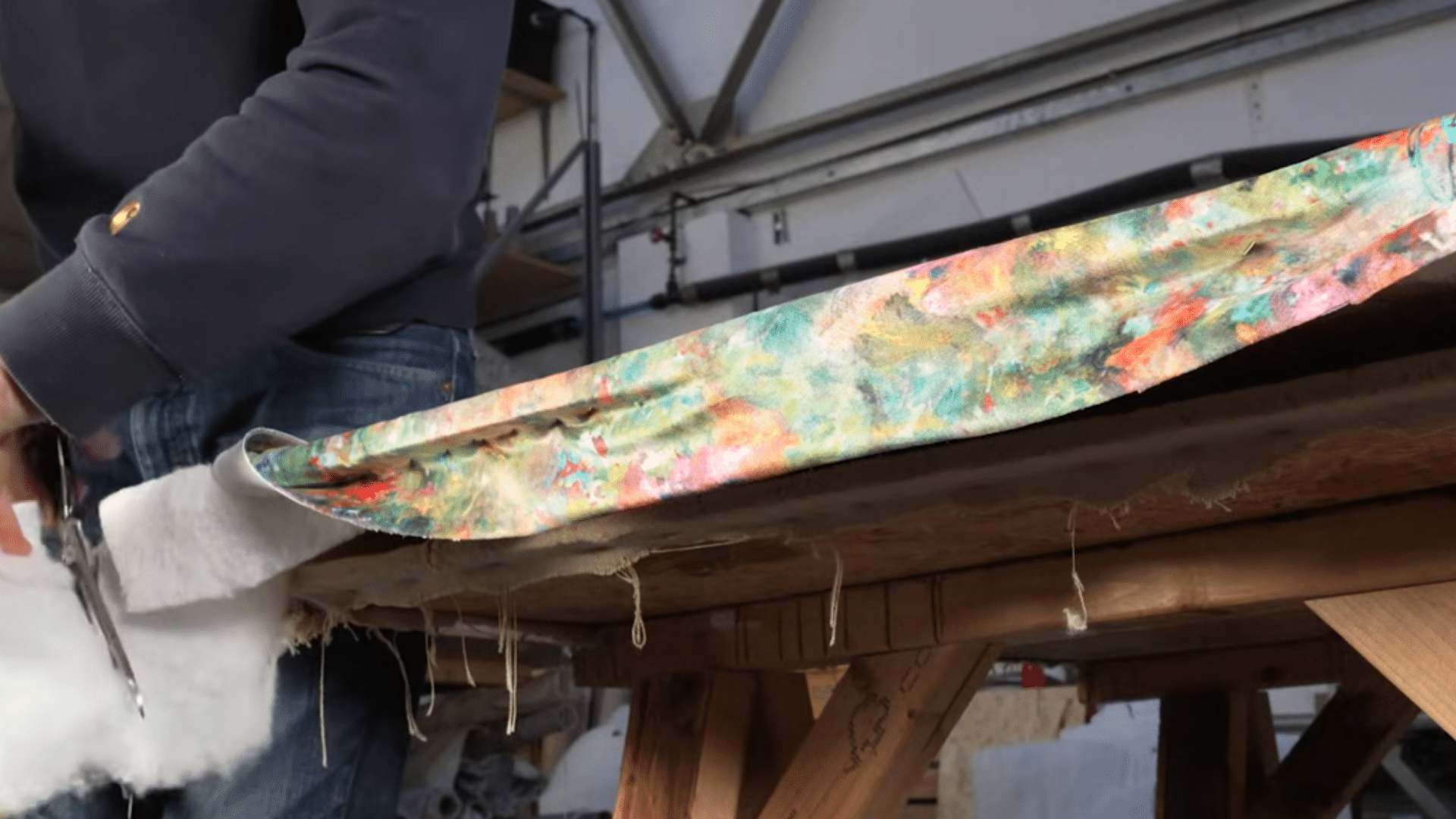 stapling calico fabric lining onto back of upholstered headboard for neat finished appearance