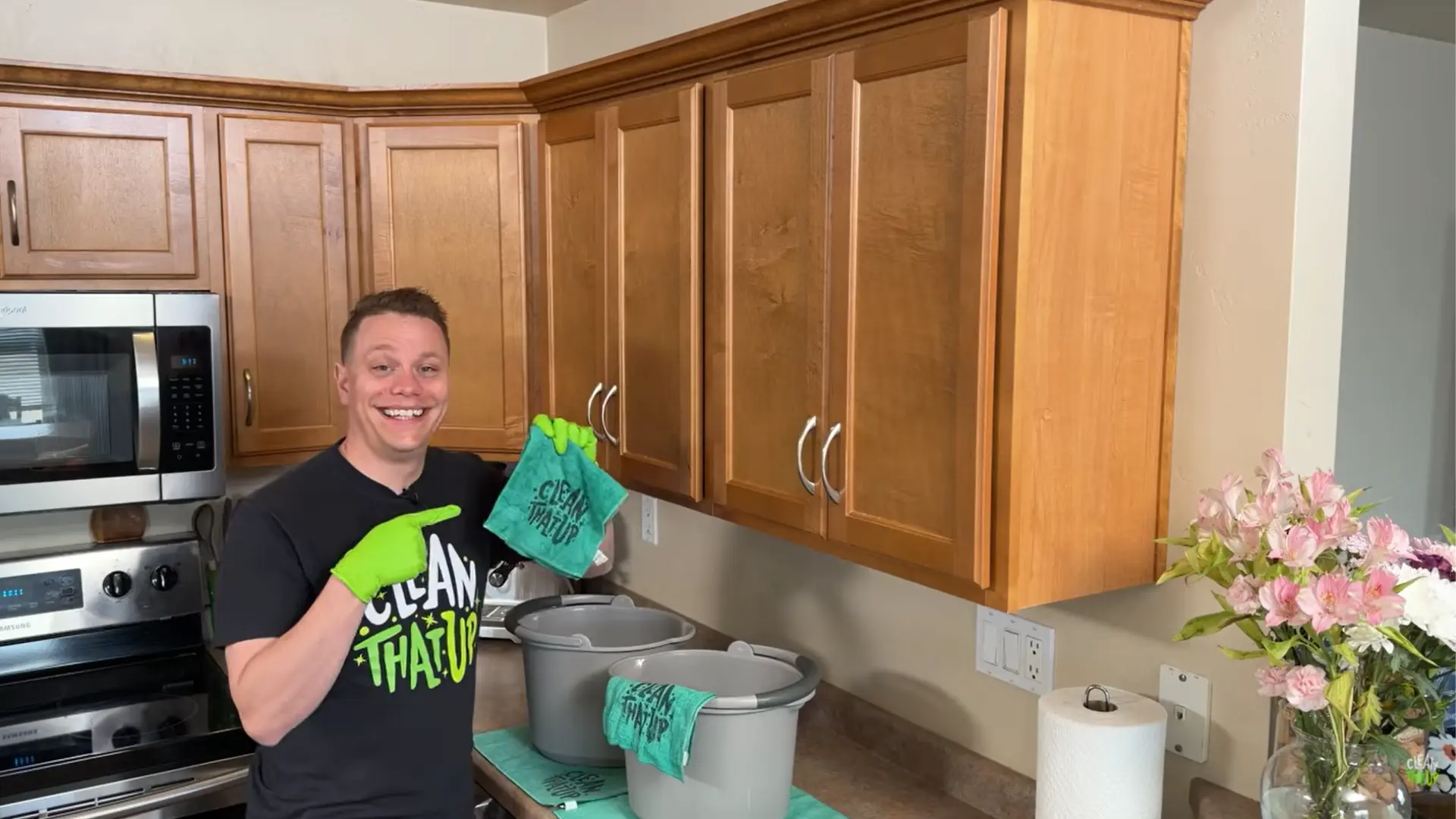 person holding microfiber towels and buckets for a three-towel system to clean wood cabinets safely