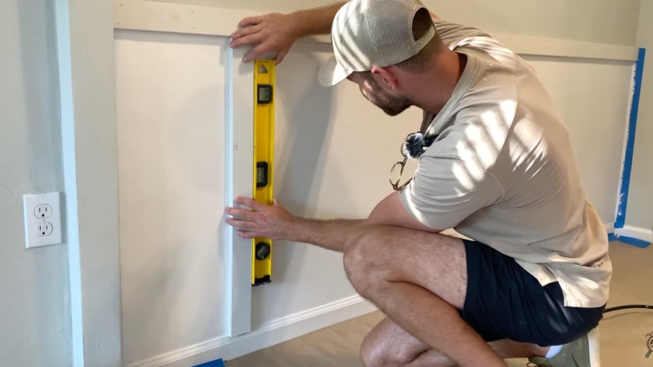 vertical board being checked with a level