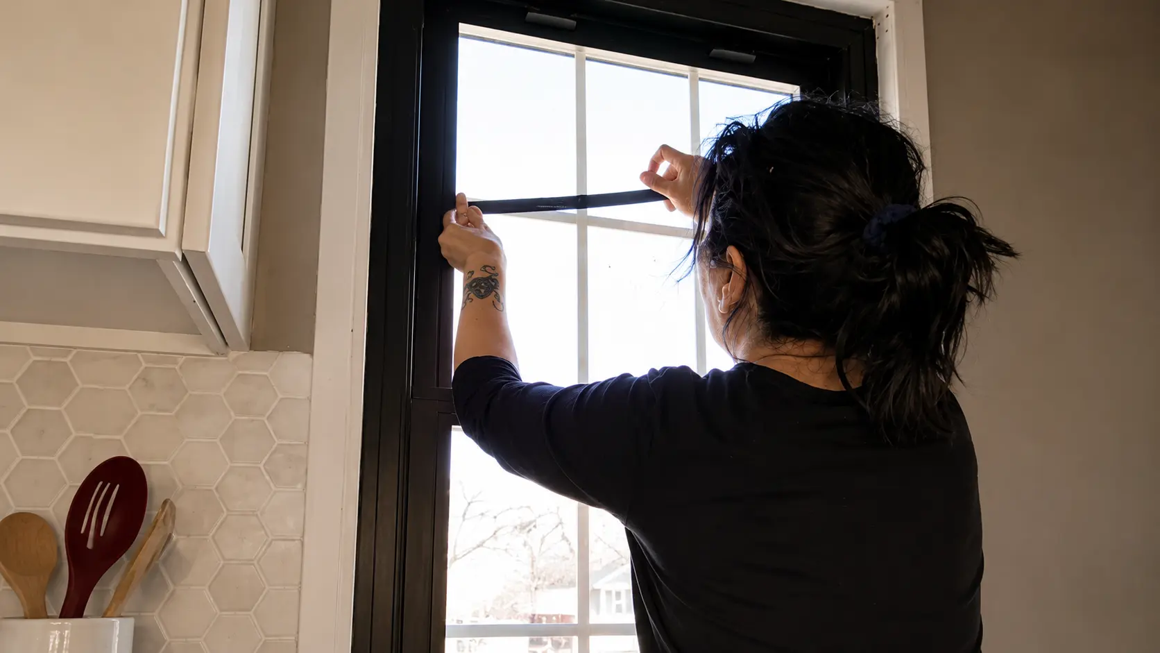 black electrical tape covering white window grids inside the glass
