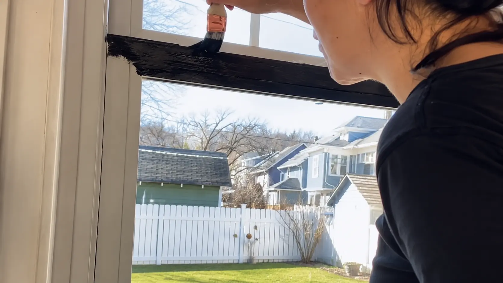 black paint brushed onto a primed vinyl window frame in thin coats