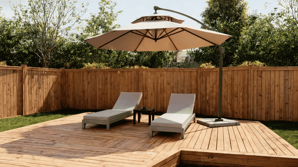 covered deck ideas on a budget with a cantilever umbrella shading two chairs on a wood deck corner