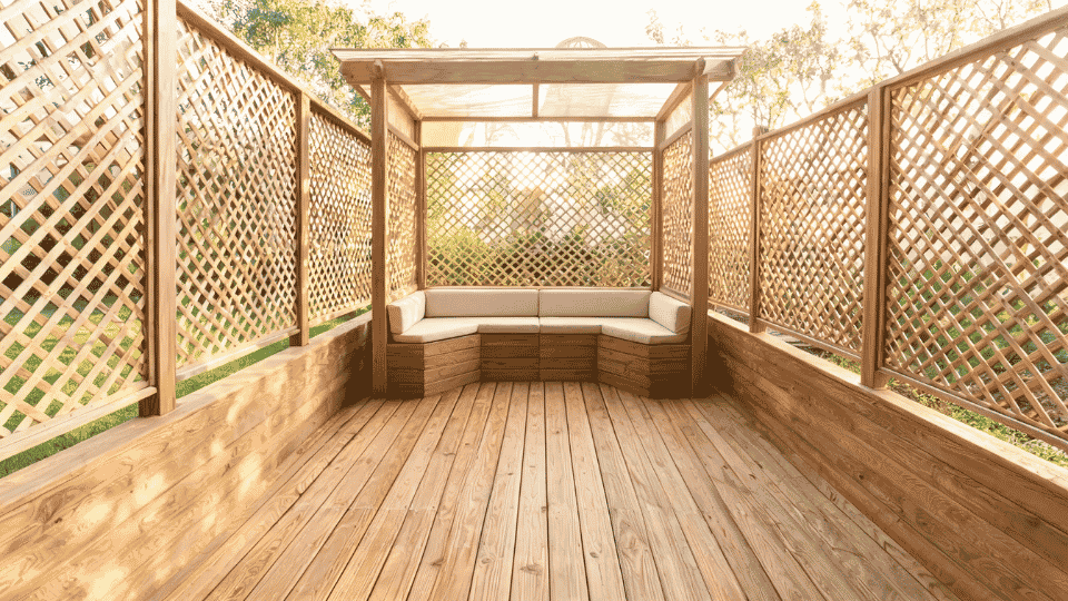 covered deck ideas on a budget with a shaded bench nook framed by lattice screens on a wood deck