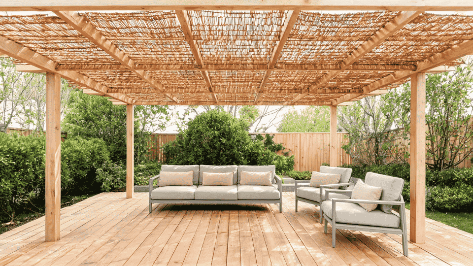 covered deck ideas on a budget with seating in soft shade under a reed mat pergola cover