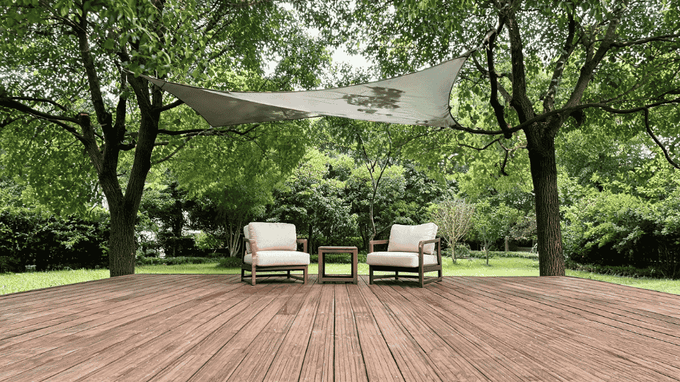 covered deck ideas on a budget with chairs softly shaded by trees and a small shade sail