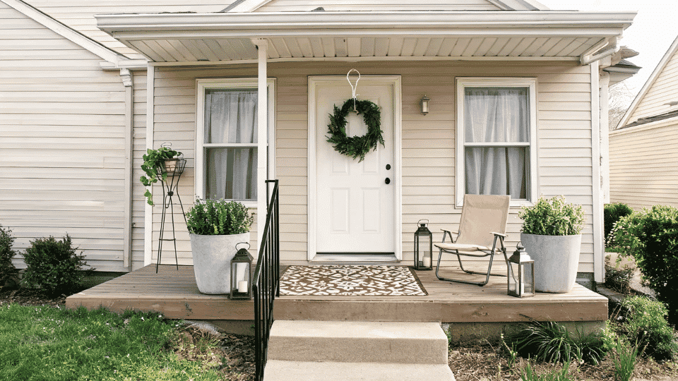 front porch decorating ideas with renter friendly planters, lanterns, rug, chair, and wreath