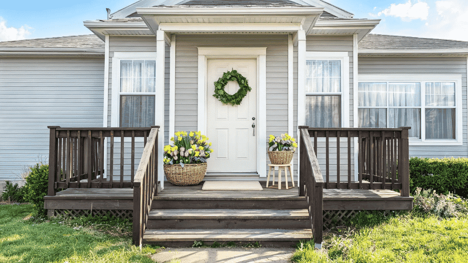 front porch decorating ideas with spring basket planters, tulips, wreath, and light mat