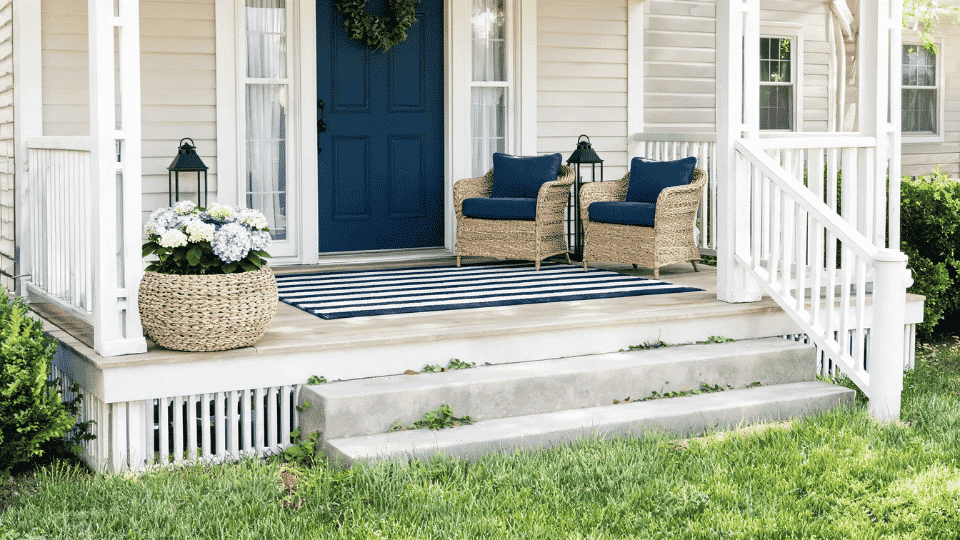 front porch decorating ideas with striped rug, woven planter, coastal cushions, and summer decor