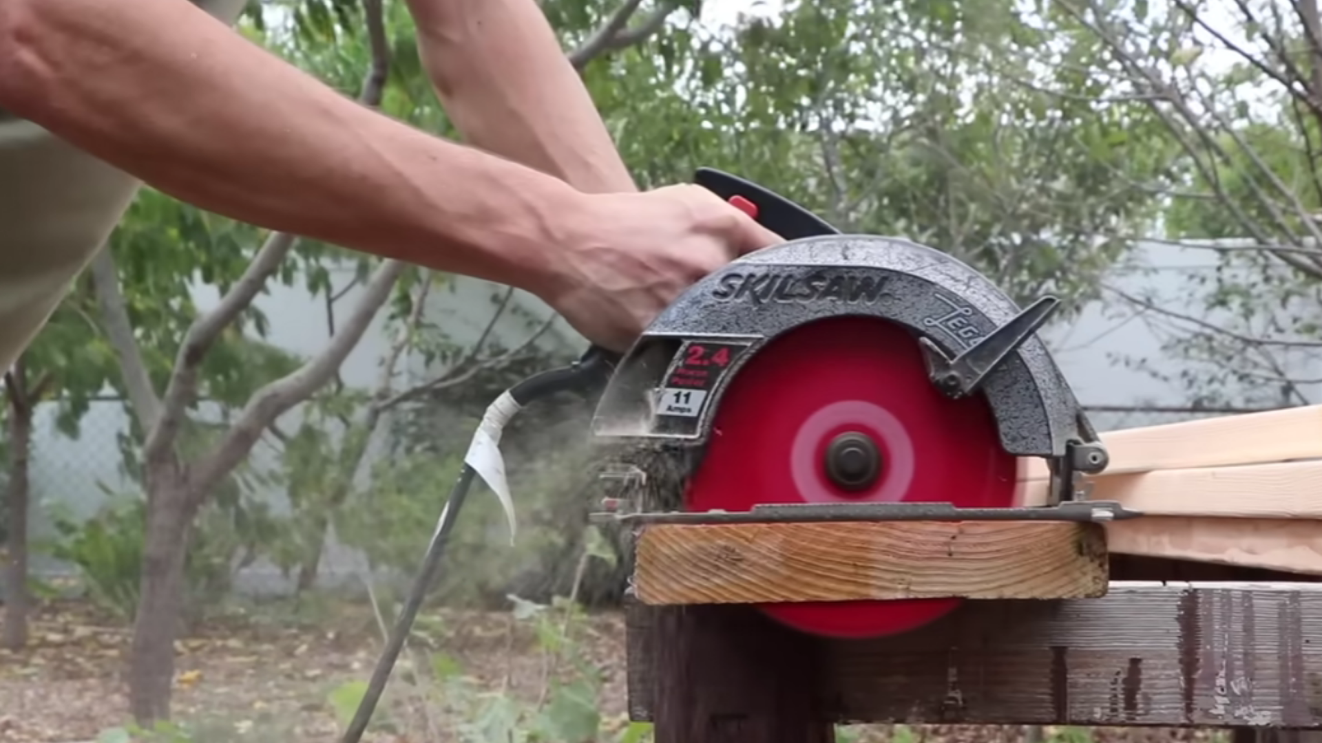 measuring and cutting untreated wood boards for a raised garden bed frame