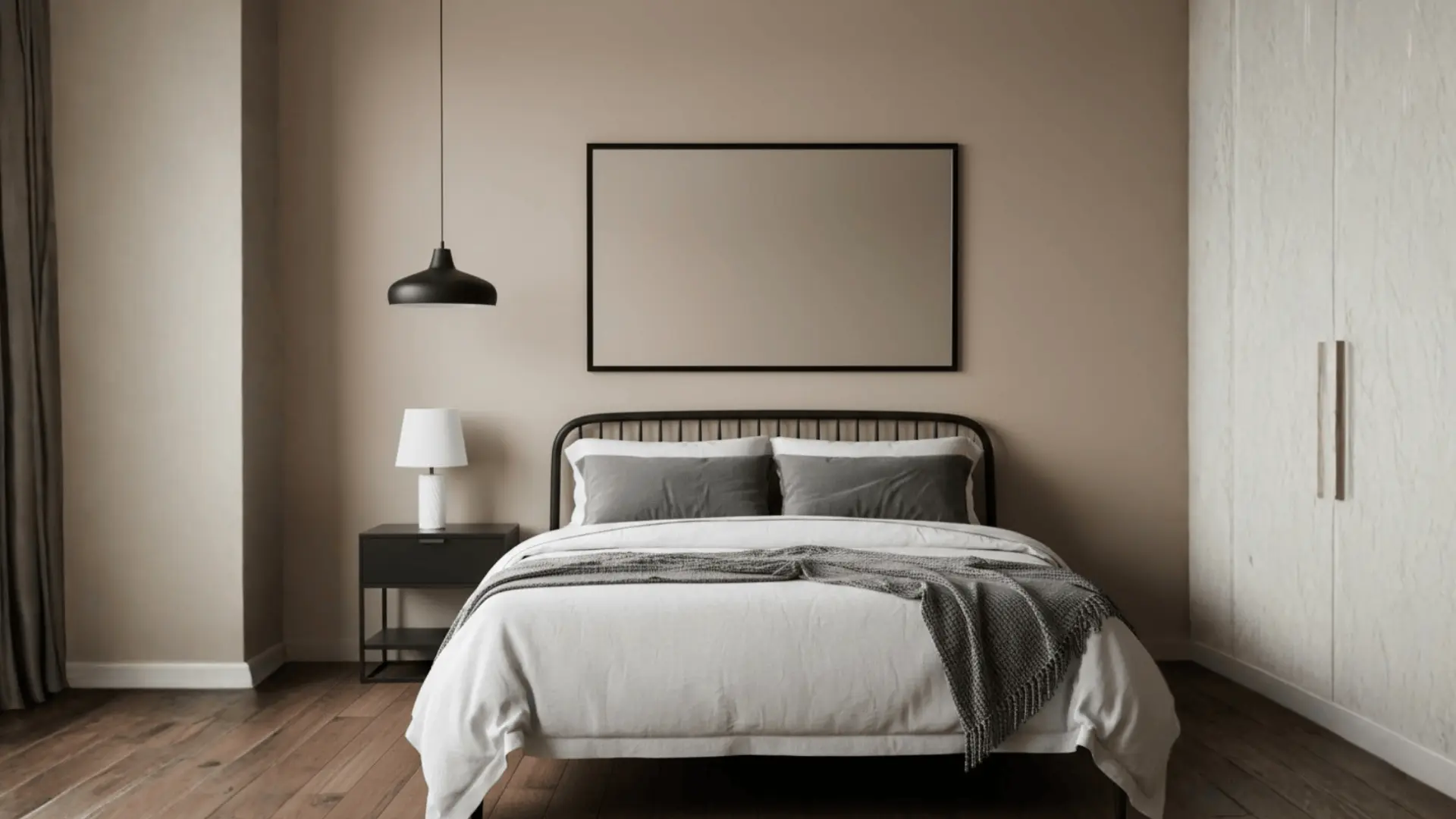 Minimalist bedroom with black metal bed frame, dark pendant light, grey bedding, and dark wood floors
