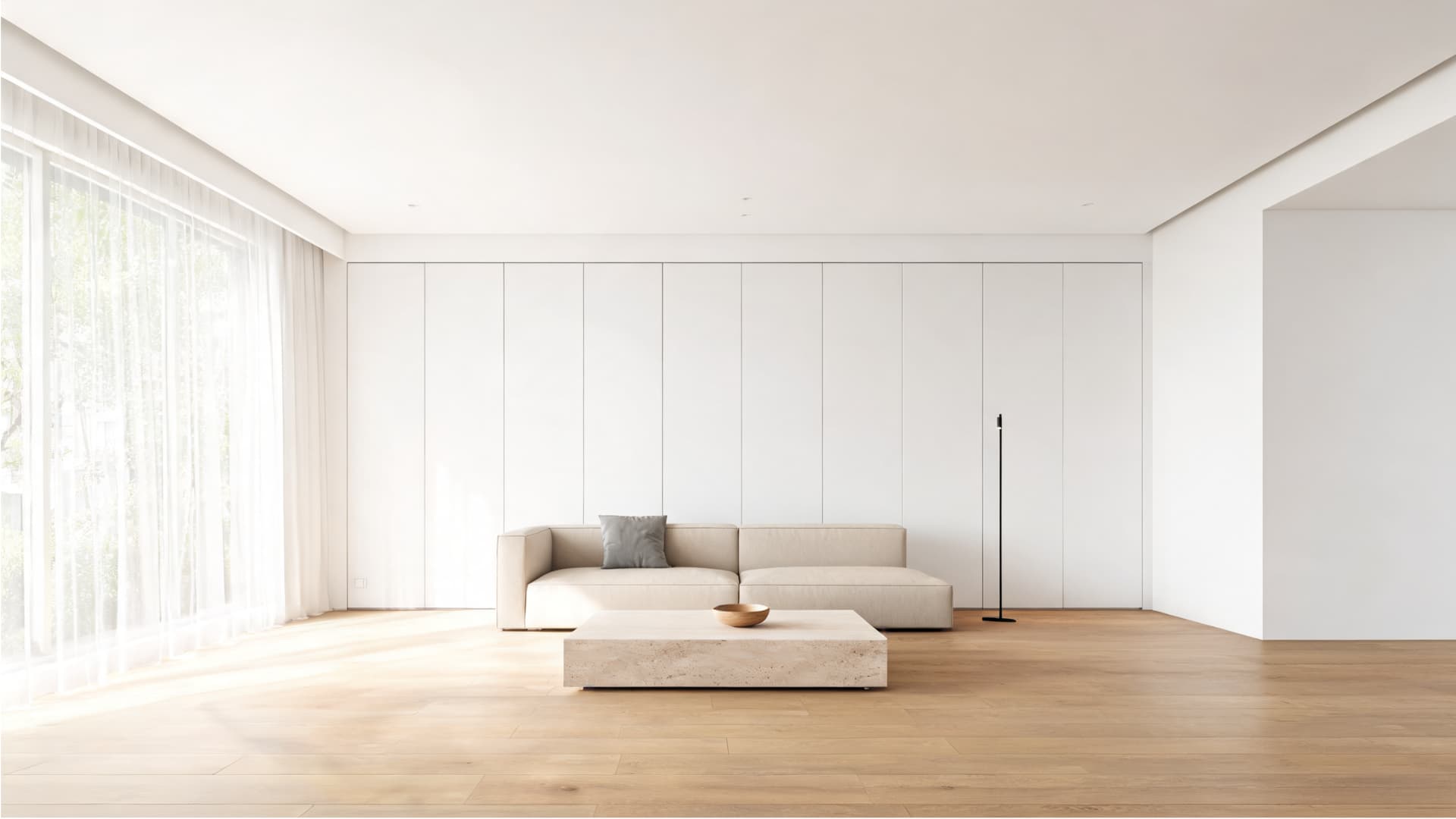 minimalist living room with open space, pale wood floors, hidden storage, simple sofa, and soft natural light
