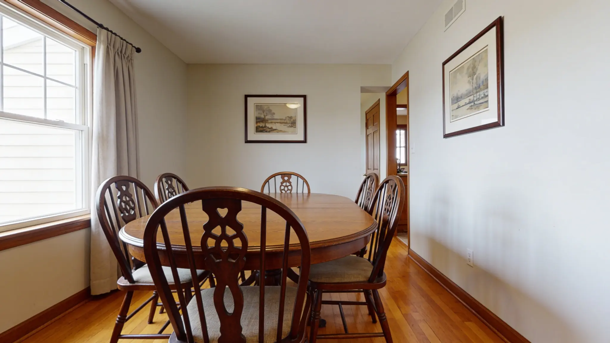 Oval dining table in a narrow dining room with rounded ends