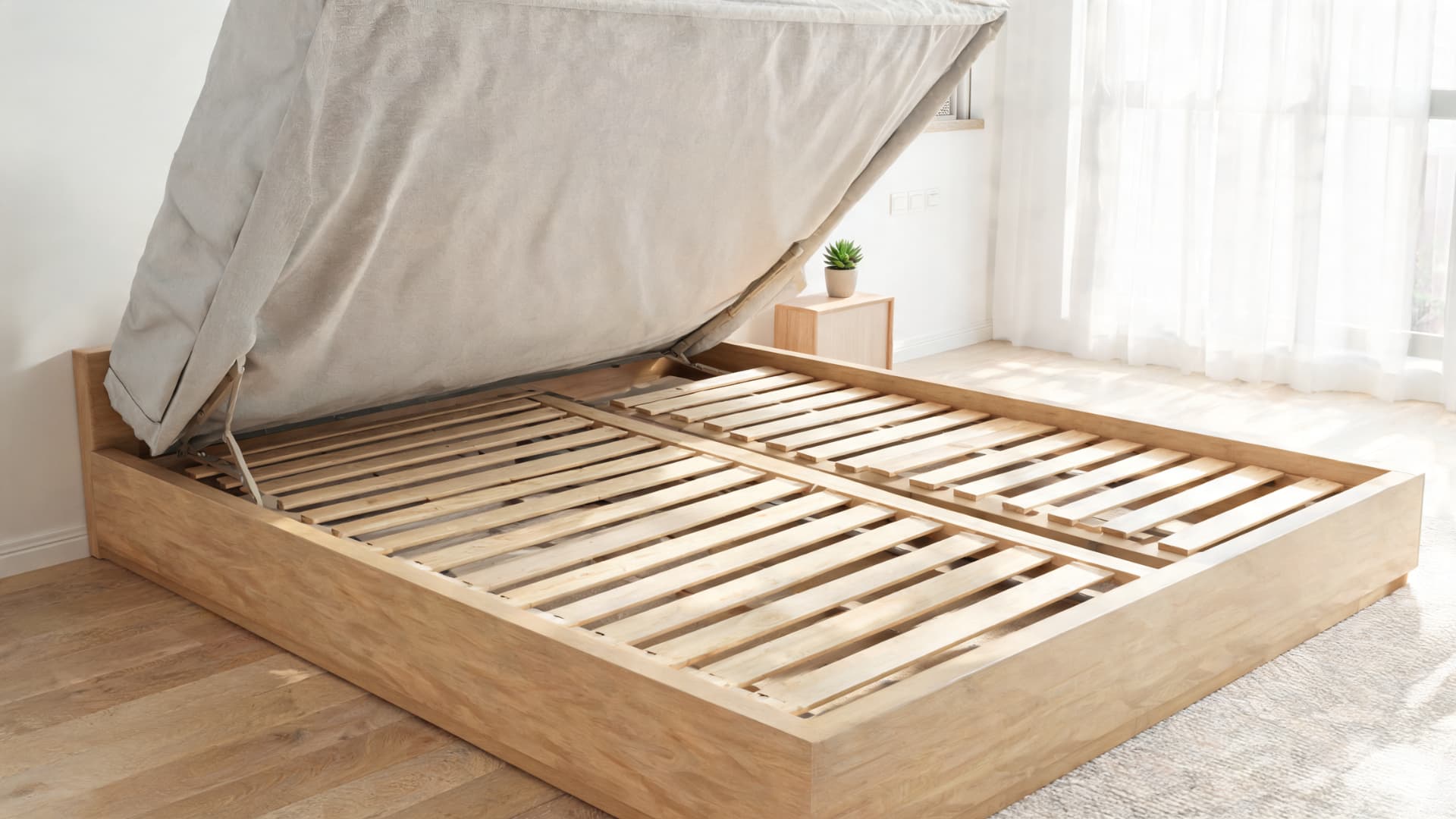 wood bed frame with lifted mattress showing slats and center support beam in a bright bedroom