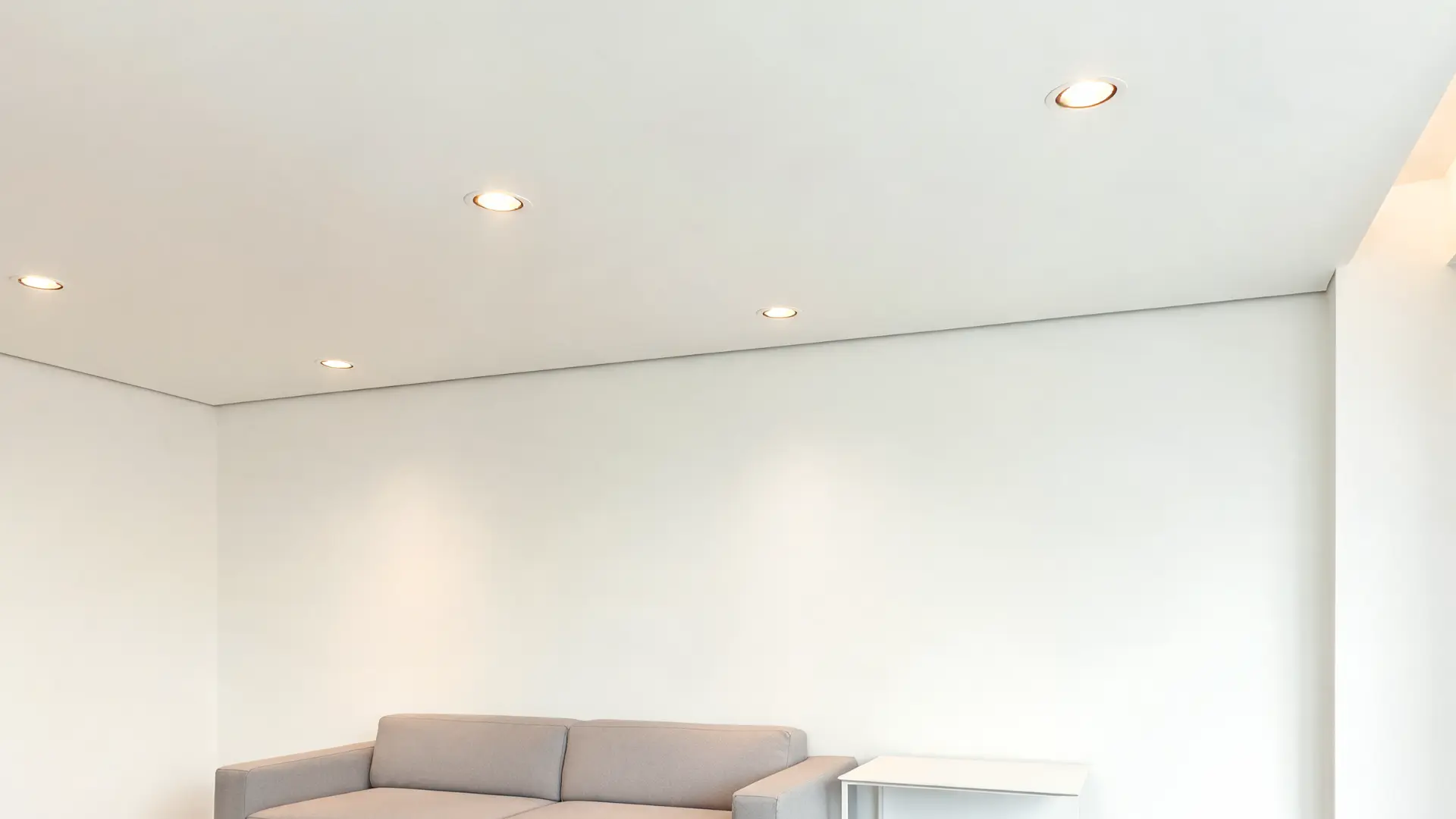 smooth drywall wall and ceiling with clean lines, modern recessed lighting and sleek furniture