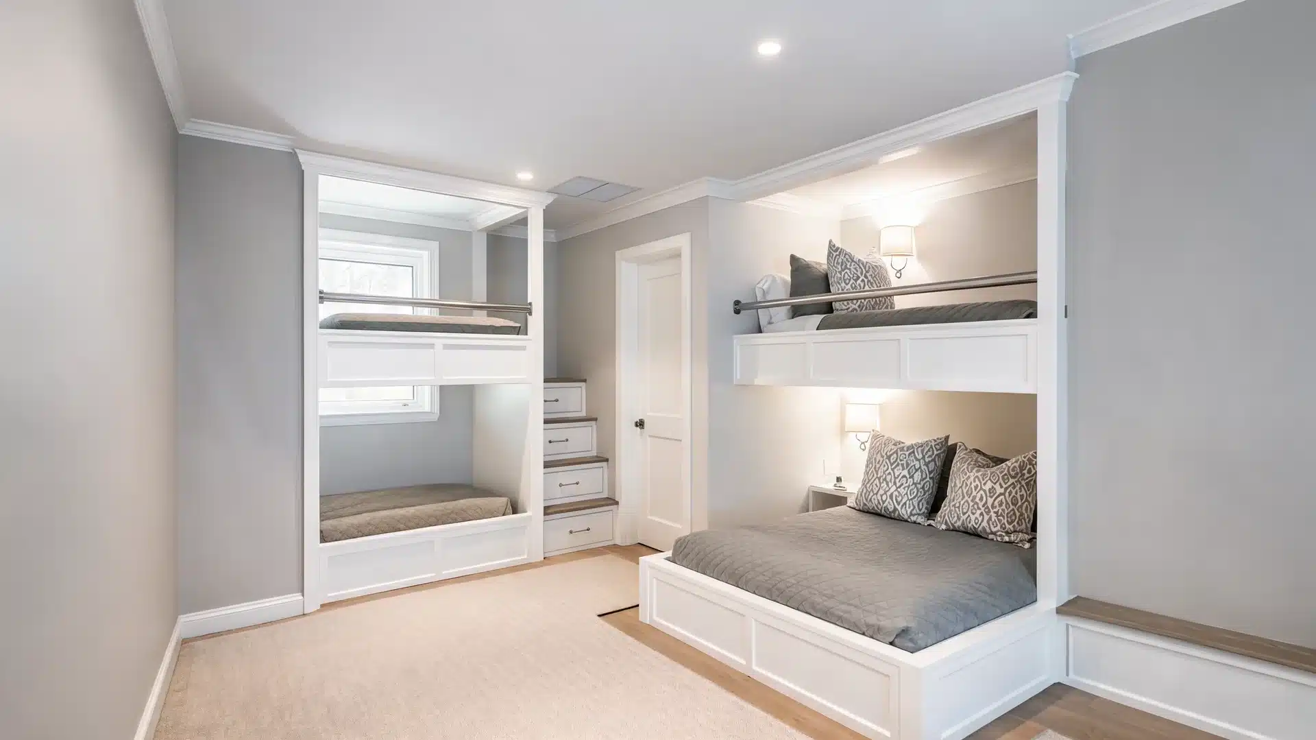 wall to wall built in bunk bed in a narrow kids room with trim and soft bedding