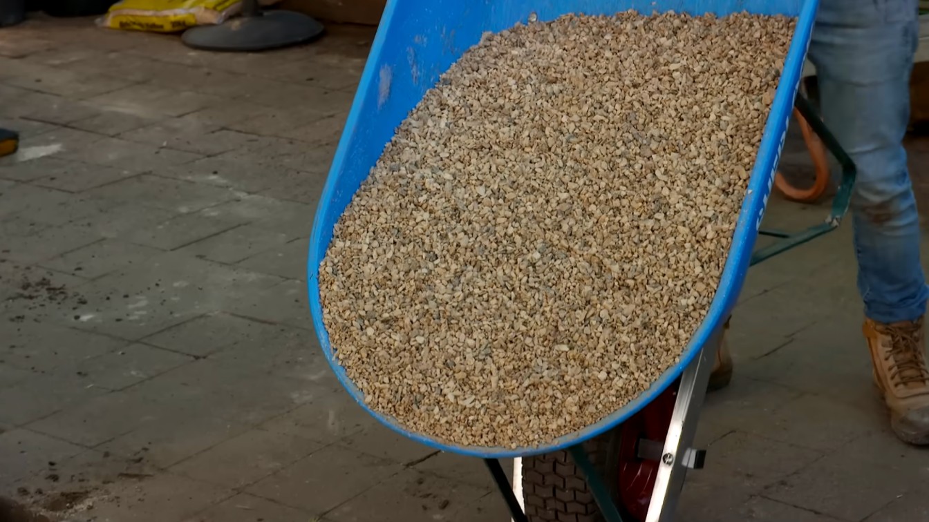 wheelbarrow full of small decorative gravel for backyard garden path and landscape edging work