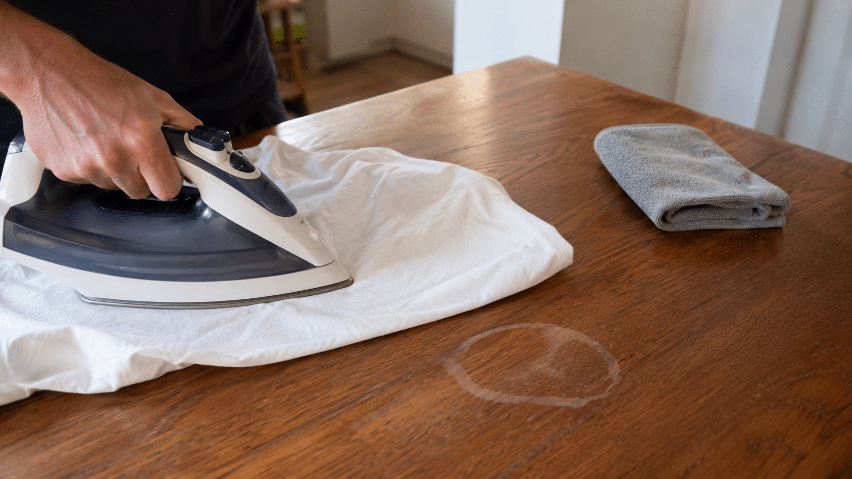 iron and cotton cloth used on a white water ring to lift trapped moisture from a wood finish