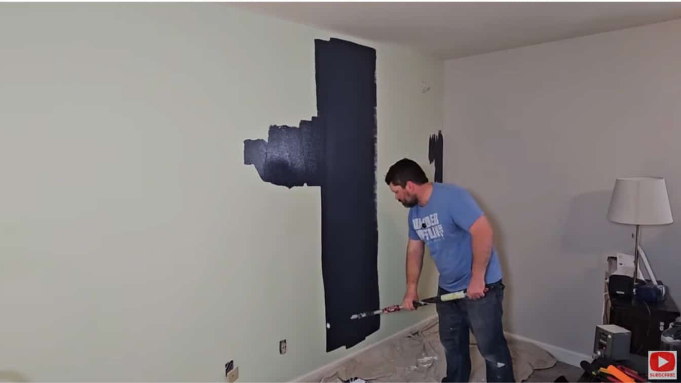 board and batten diy project with dark navy paint rolled onto wall before adding trim boards and battens