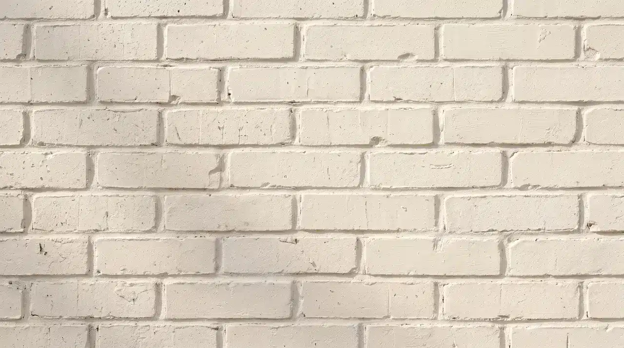 Warm off-white brick stain softens a textured brick wall while preserving its natural surface details.