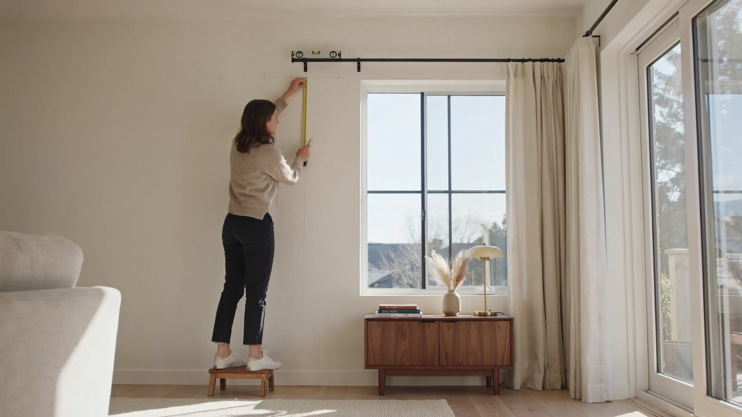 Measuring curtain length from the rod to the floor with a tape measure