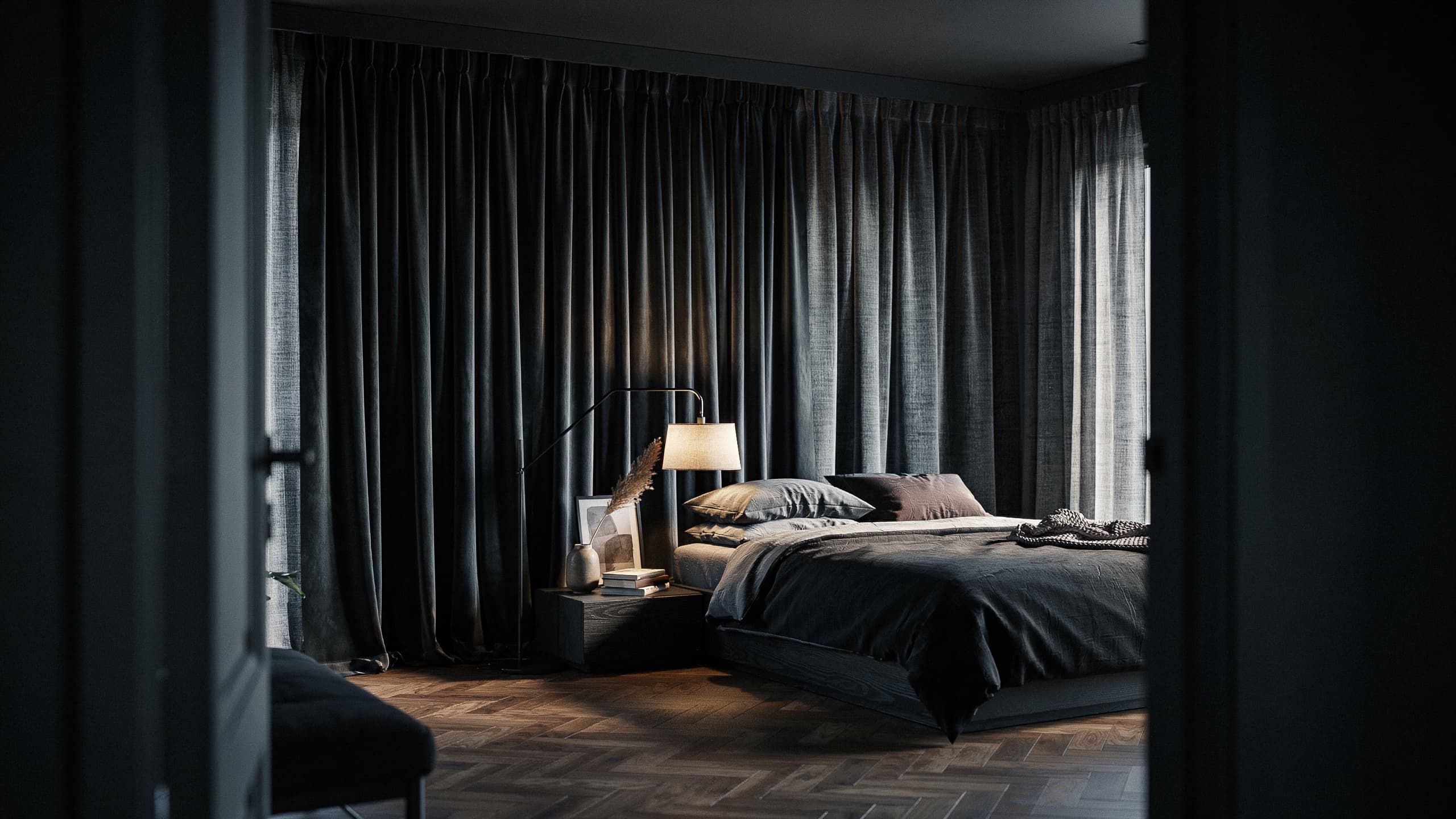Black bedroom with floor-to-ceiling curtains and layered dark textiles